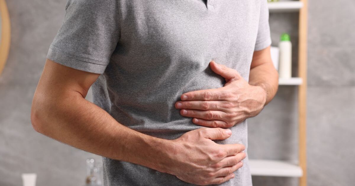 Man experiencing upper abdominal pain, representing digestive discomfort