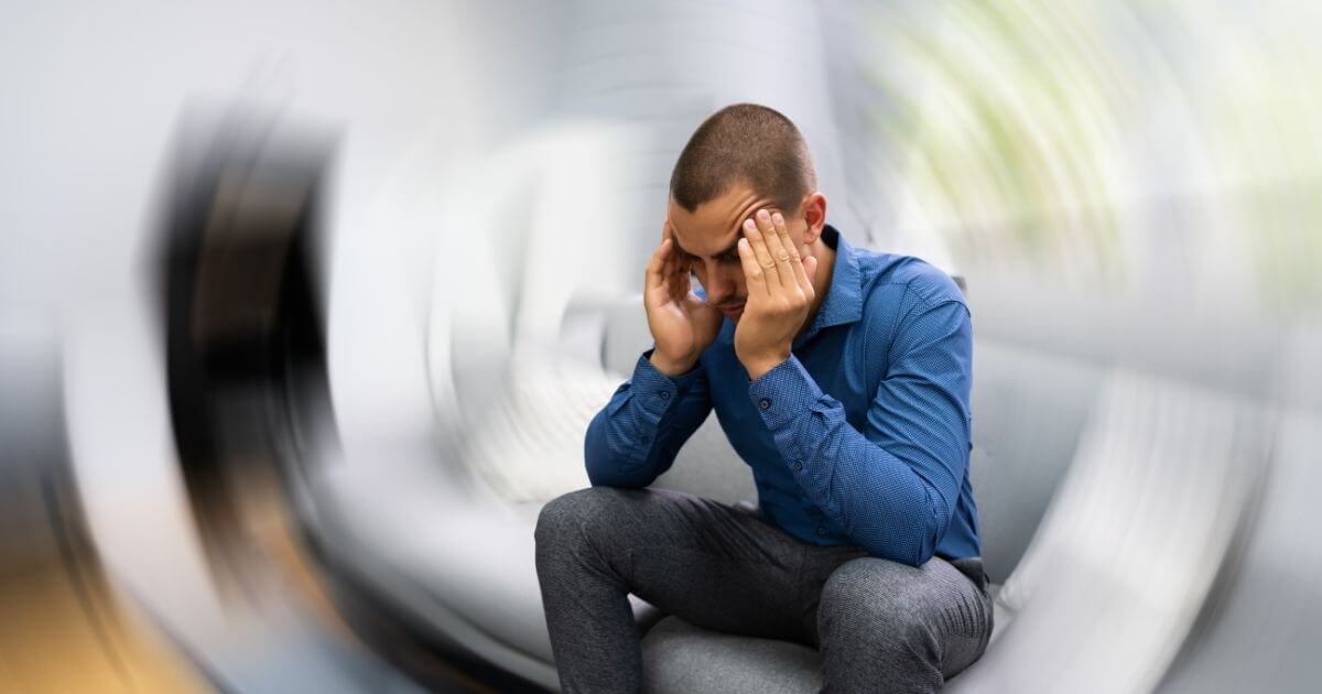 Man experiencing dizziness, illustrating systemic symptoms linked to gut issues
