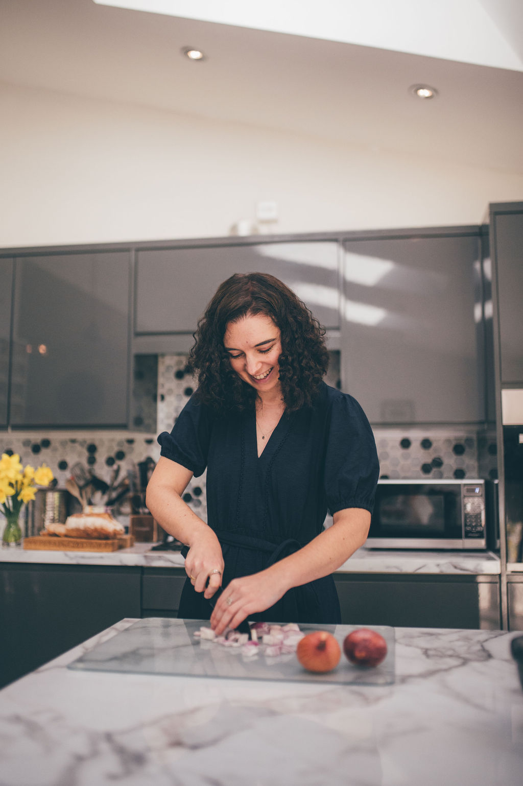 Lucy cooking with some vegetables in her kitchen