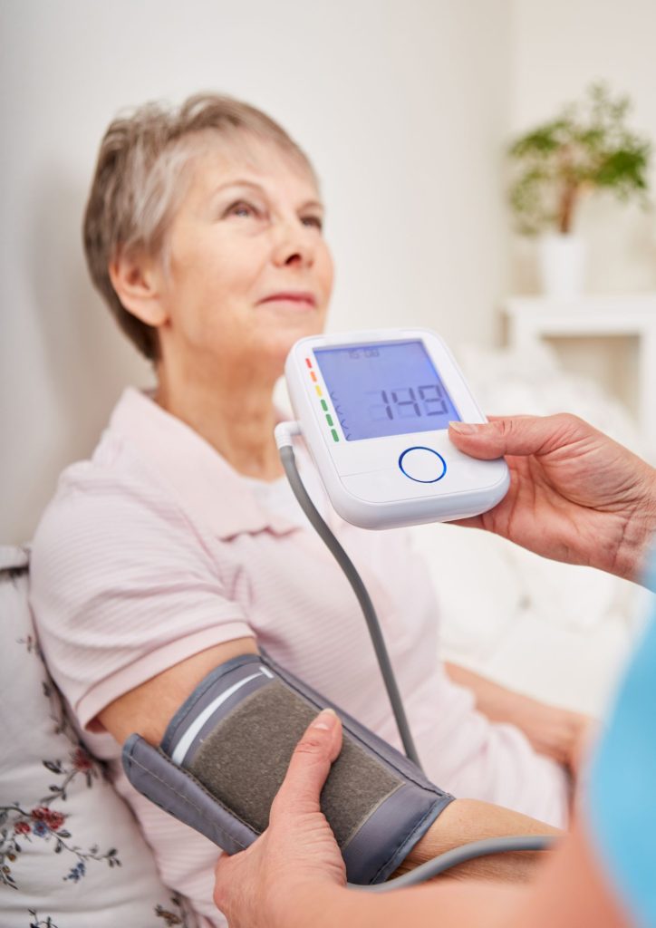Measuring blood pressure of elderly woman