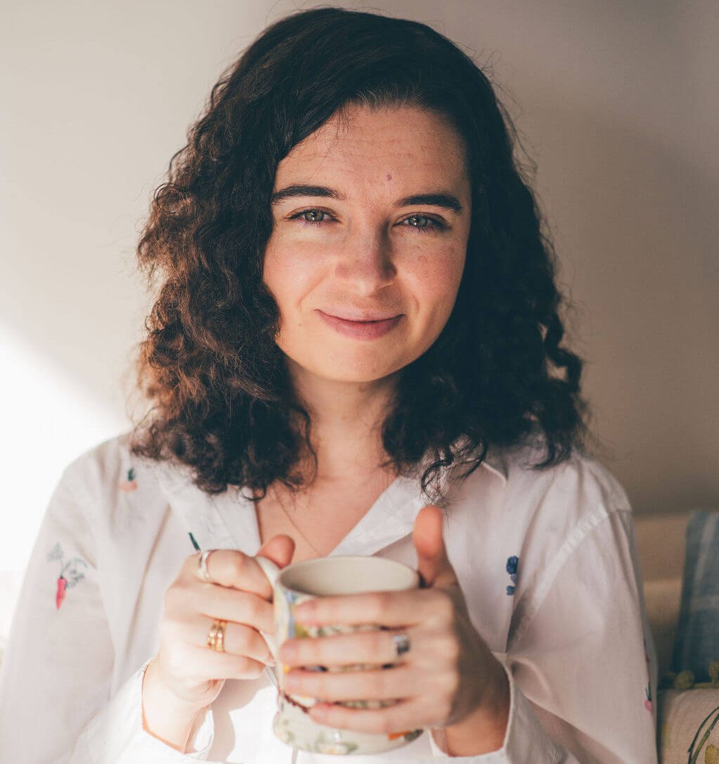 Lucy, nutritional therapist specialising in gut health, holding a cup of tea and smiling