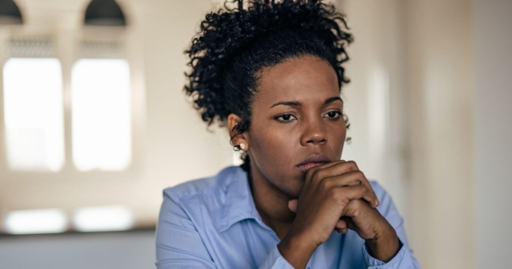Woman looking anxious while experiencing ongoing gut symptoms
