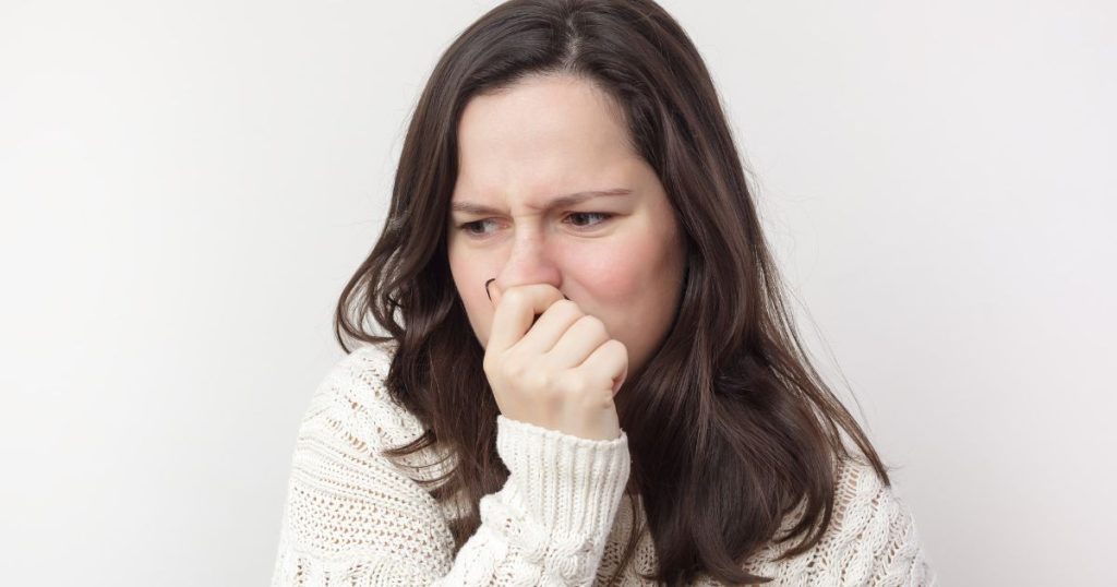 Woman covering her nose in response to a bad smell associated with hydrogen sulphide SIBO gas.