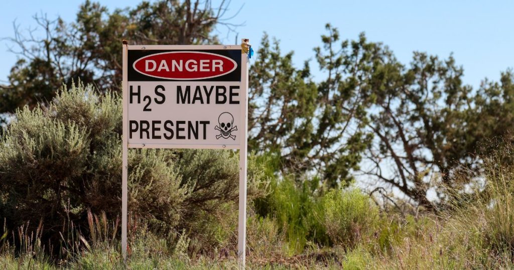 Outdoor warning sign stating hydrogen sulphide may be present.